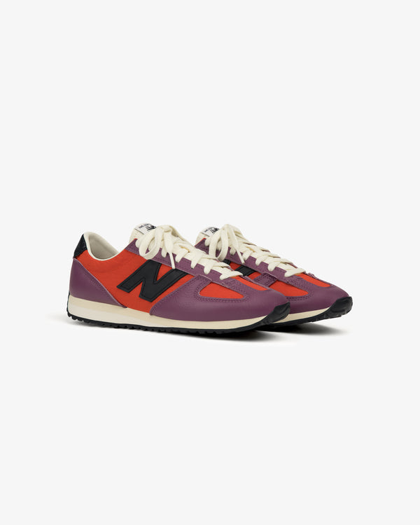 Two ALD / New Balance 471 sneakers, purple and red with white laces and black N logos, on a white background.