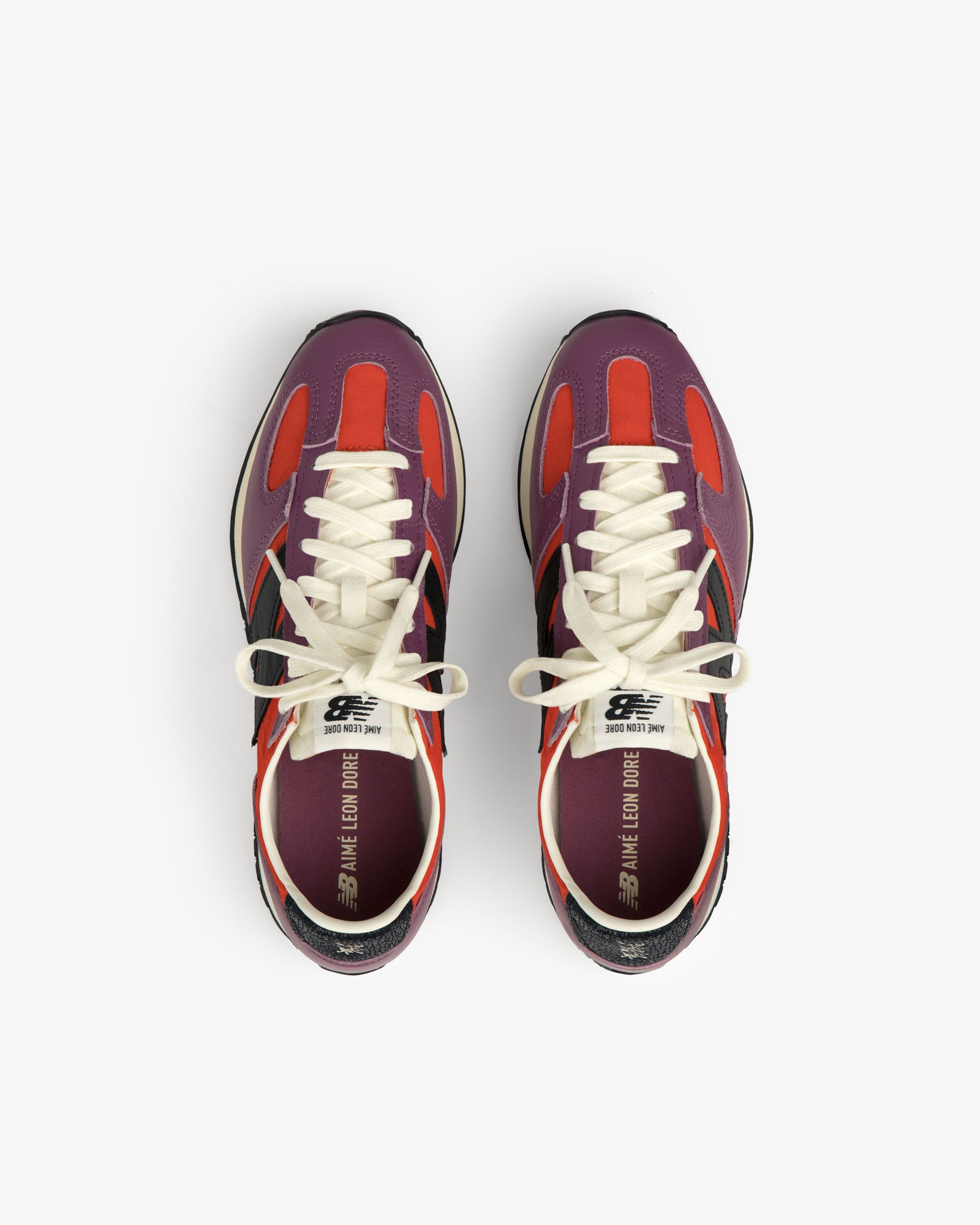 The ALD / New Balance 471 sneakers with purple, red, and black accents viewed from above on a white background.