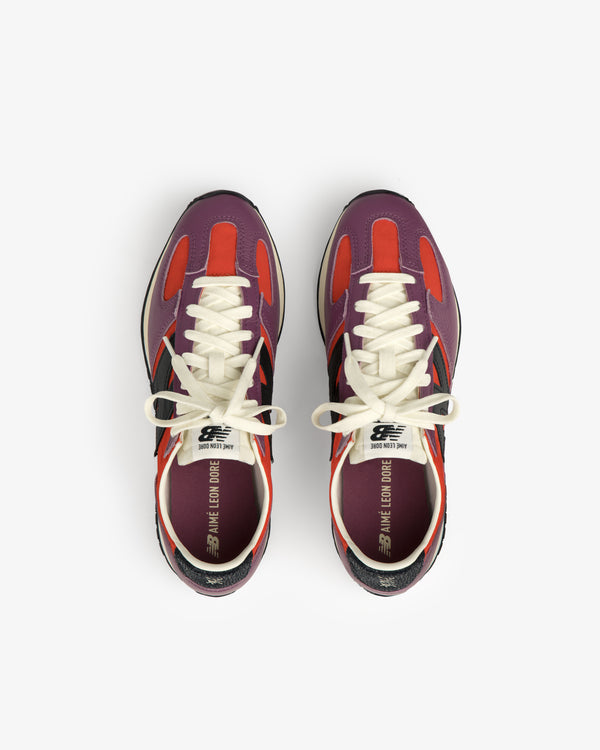 The ALD / New Balance 471 sneakers with purple, red, and black accents viewed from above on a white background.