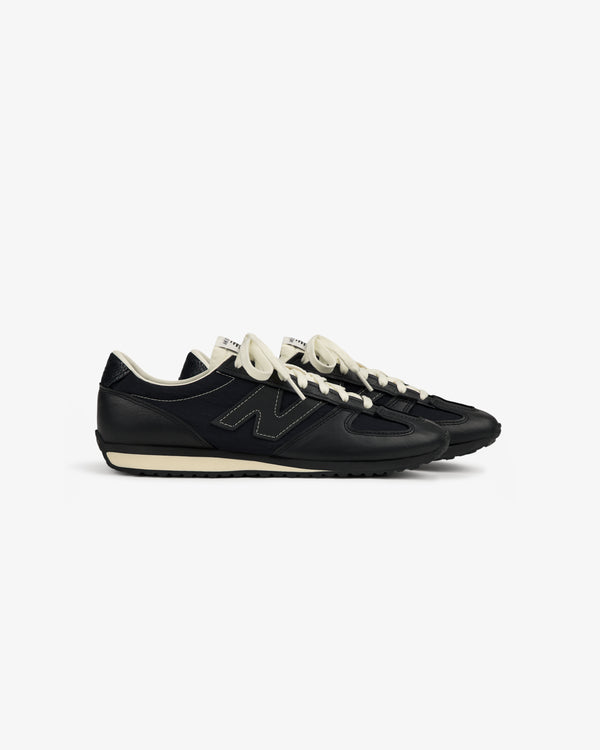 A pair of ALD / New Balance 471 sneakers in black with white laces and off-white accents on a white background.