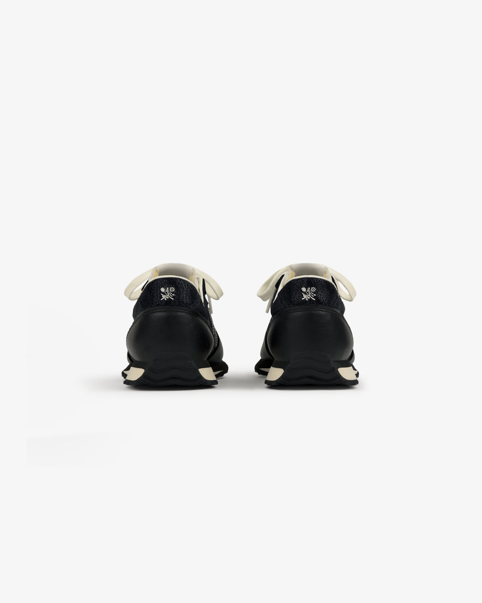 ALD / New Balance 471 black sneakers with white laces and soles, shown from the back on a plain white background.