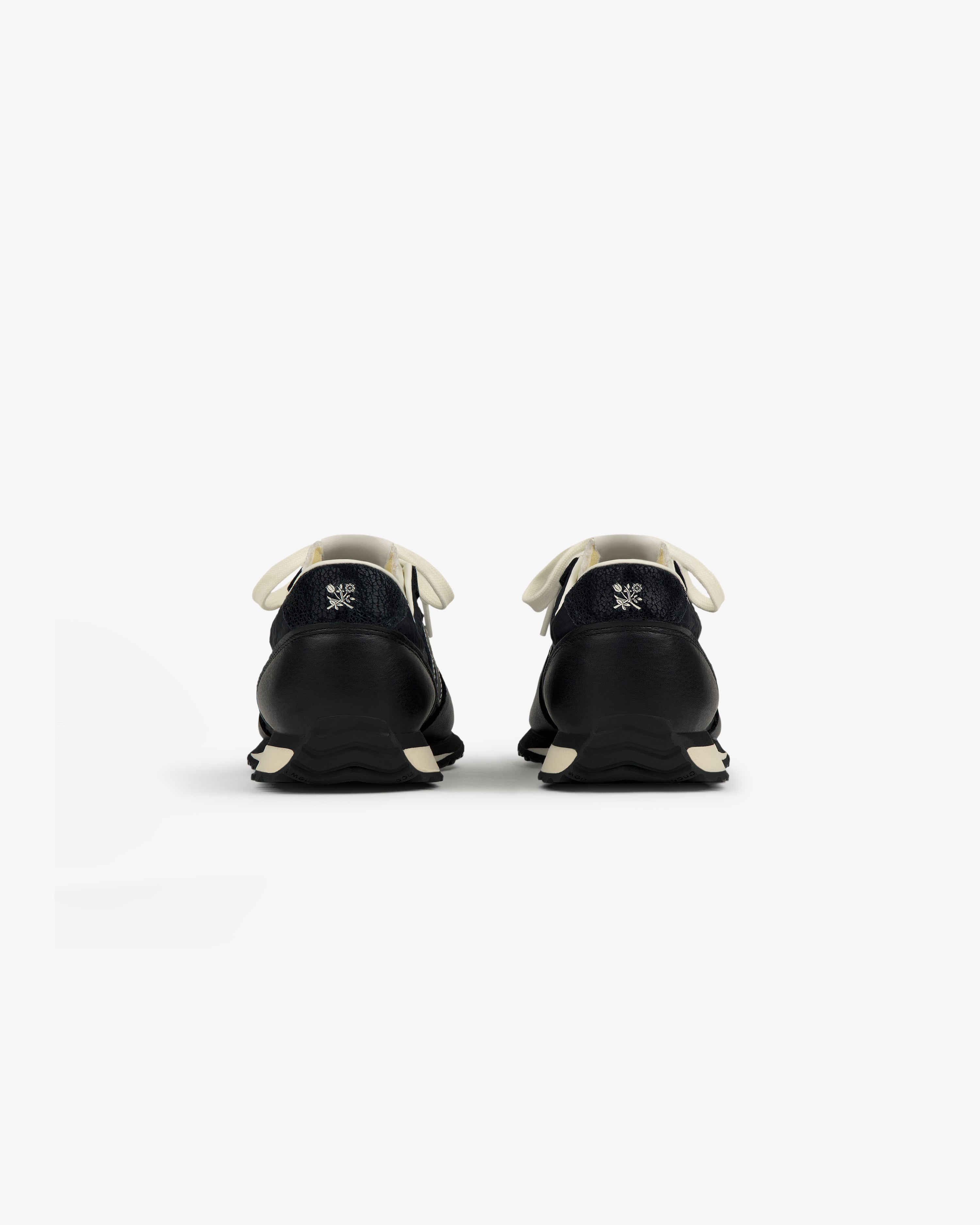 ALD / New Balance 471 black sneakers with white laces and soles, shown from the back on a plain white background.