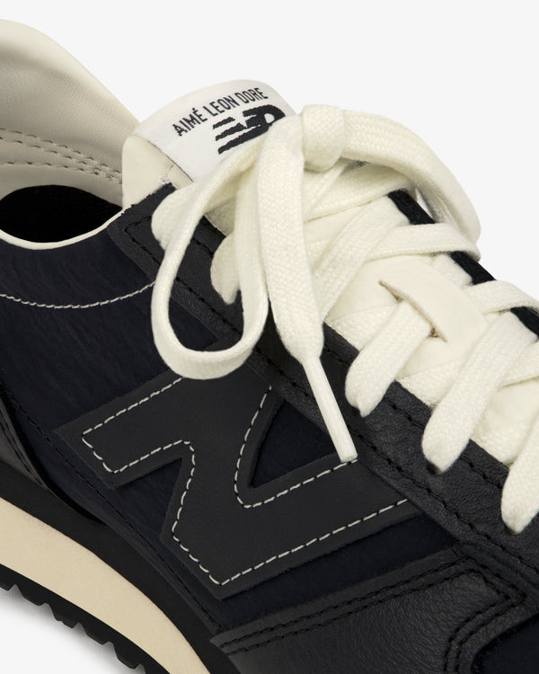 Close-up of a black ALD / New Balance 471 sneaker with white laces and Aimé Leon Dore branding on the tongue.