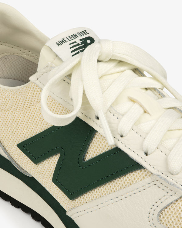 Close-up of a cream and green ALD / New Balance 471 sneaker with “Aimé Leon Dore” branding on the tongue.
