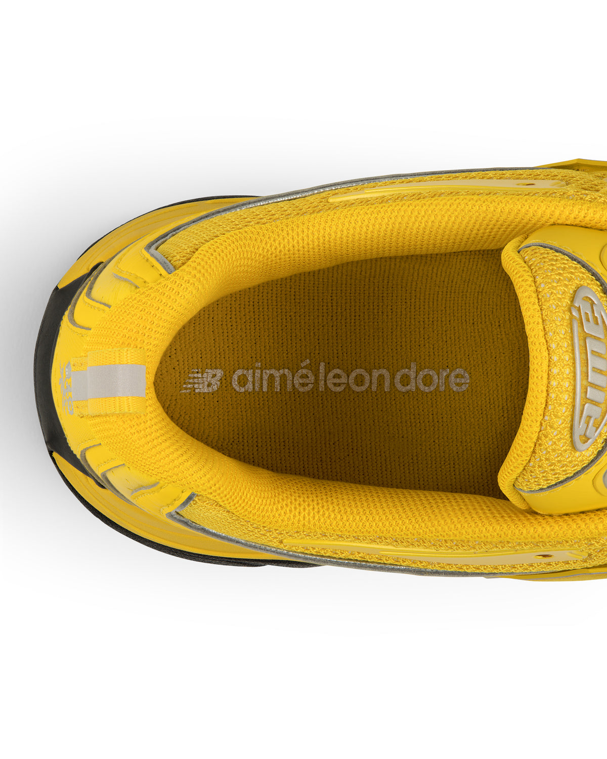 Top view of a yellow ALD / New Balance RC56 sneaker with aimé leon dore in silver on the insole.
