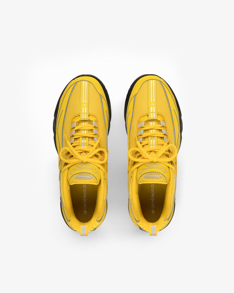 The ALD / New Balance RC56 sneakers in yellow with black soles, viewed from above on a white background.