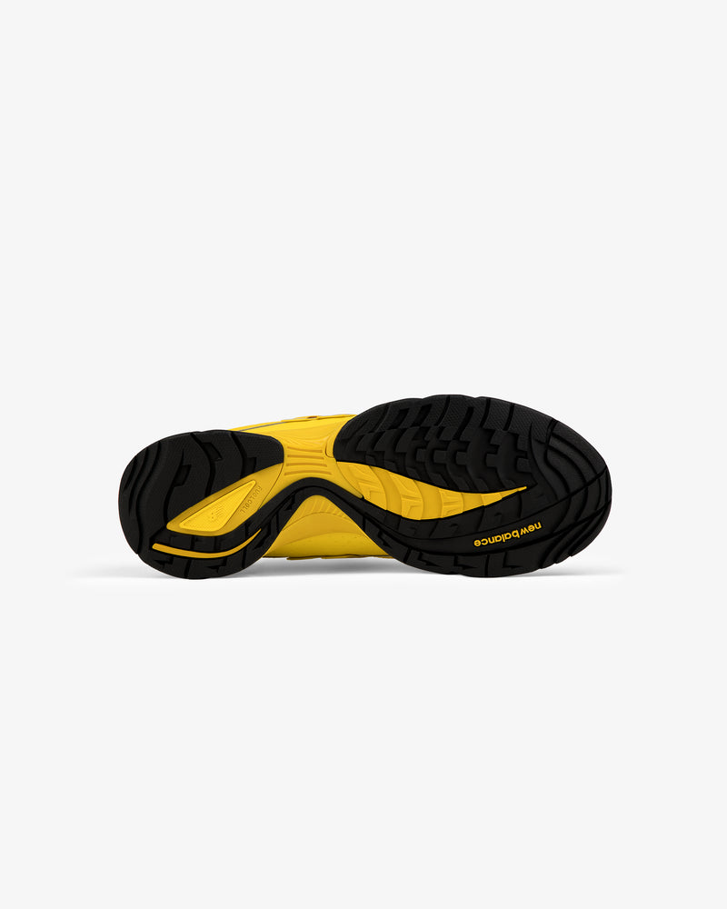 Black and yellow rubber sole of the ALD / New Balance RC56 shoe seen from below on a plain white background.