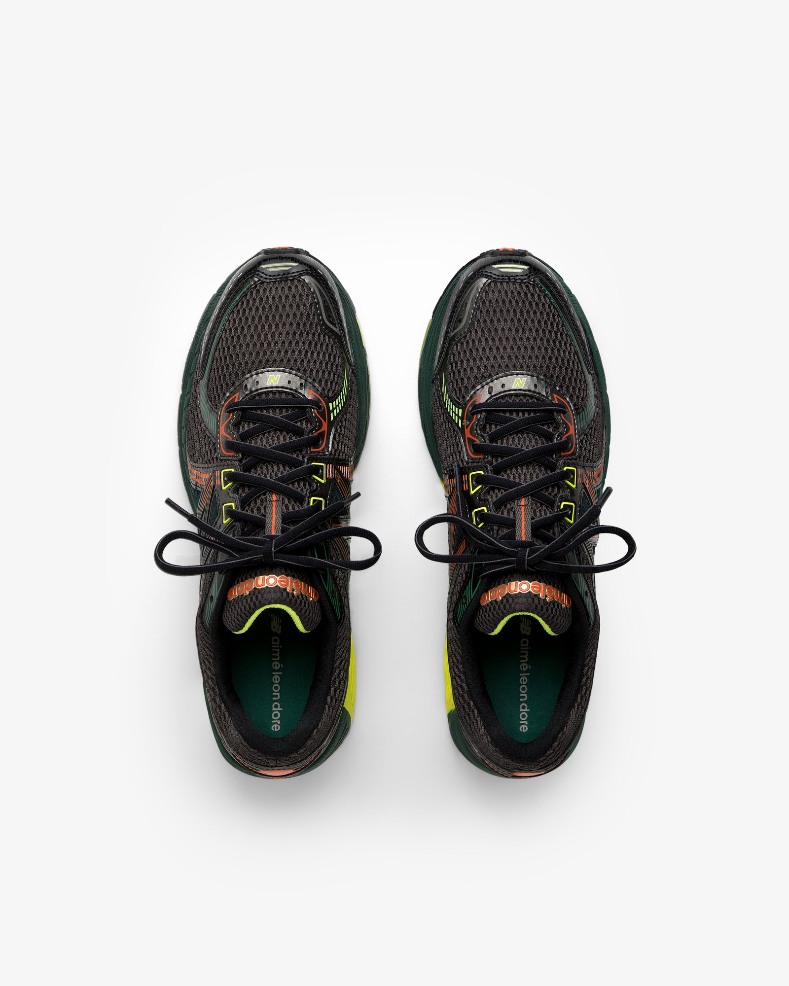 The ALD / New Balance 860v2 sneakers in black mesh with green and orange accents, shown from above on white.