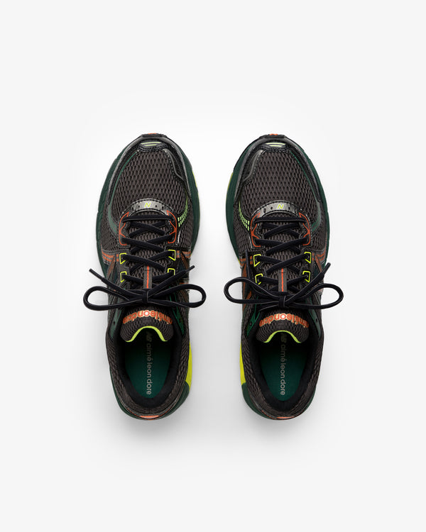 The ALD / New Balance 860v2 sneakers in black mesh with green and orange accents, shown from above on white.
