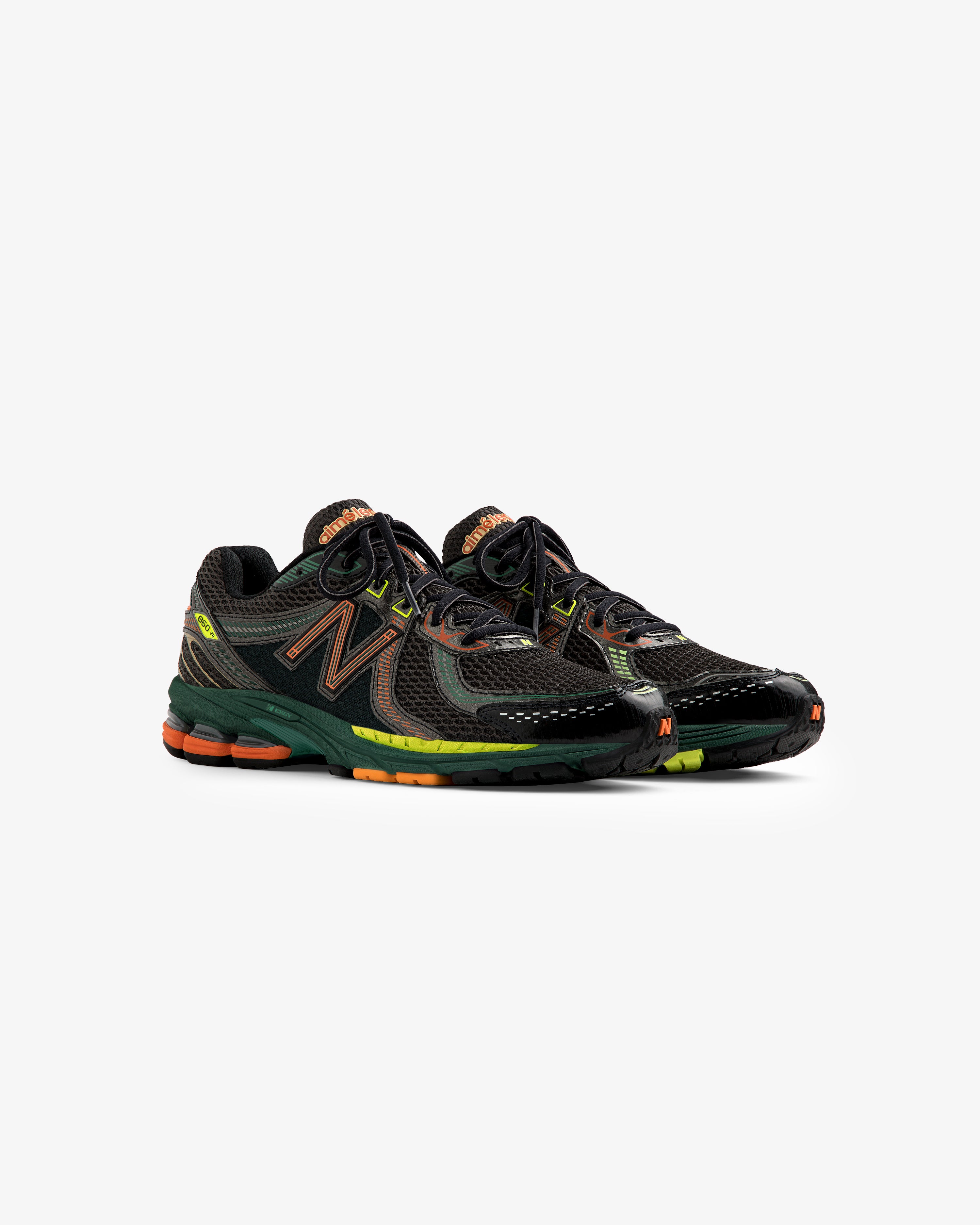 ALD / New Balance 860v2 black sneakers with green, orange, and yellow accents on a plain white background.