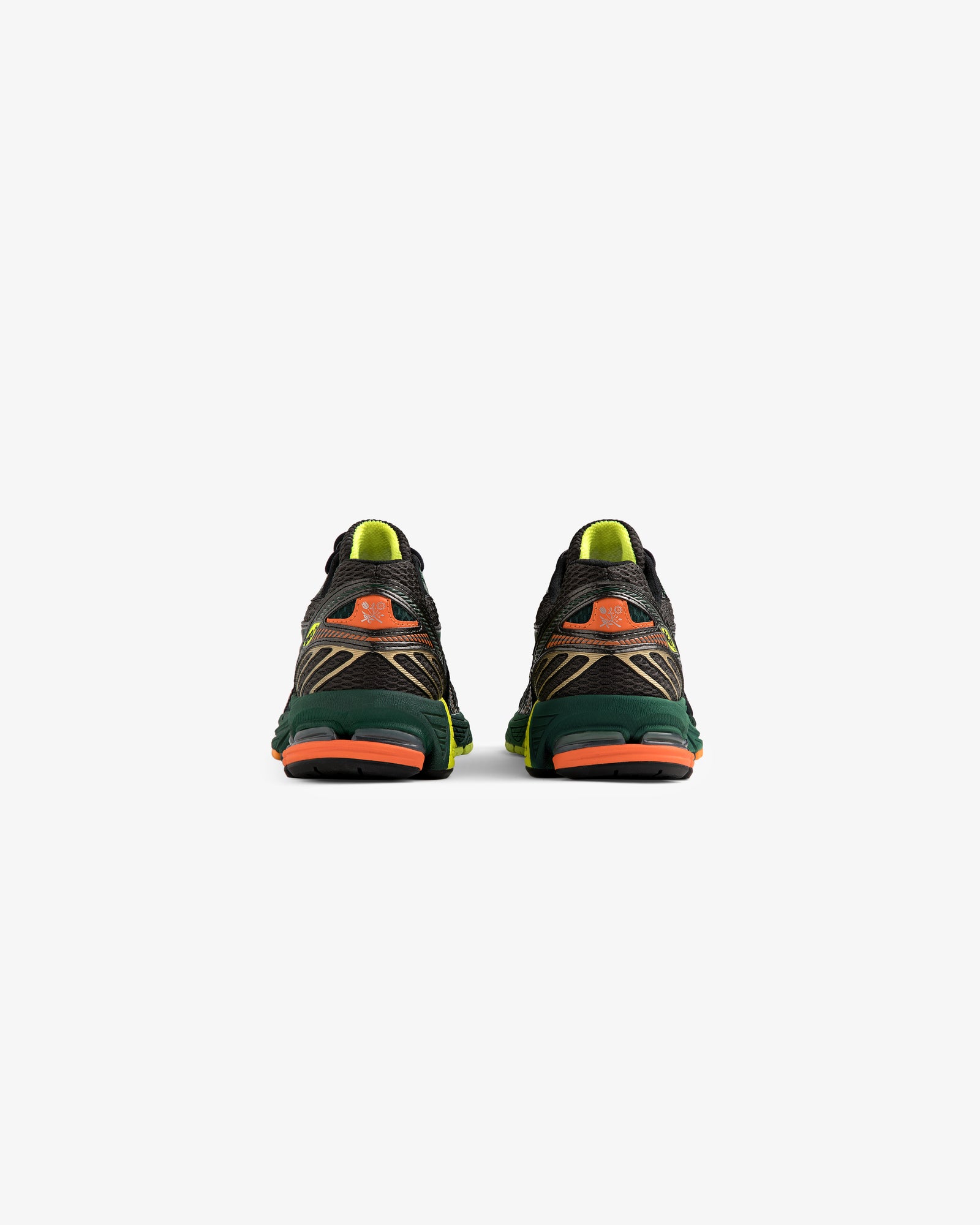 The ALD / New Balance 860v2 sneakers in black, green, and orange shown from the back on a white background.