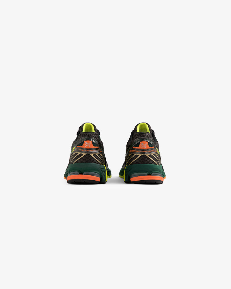 The ALD / New Balance 860v2 sneakers in black, green, and orange shown from the back on a white background.