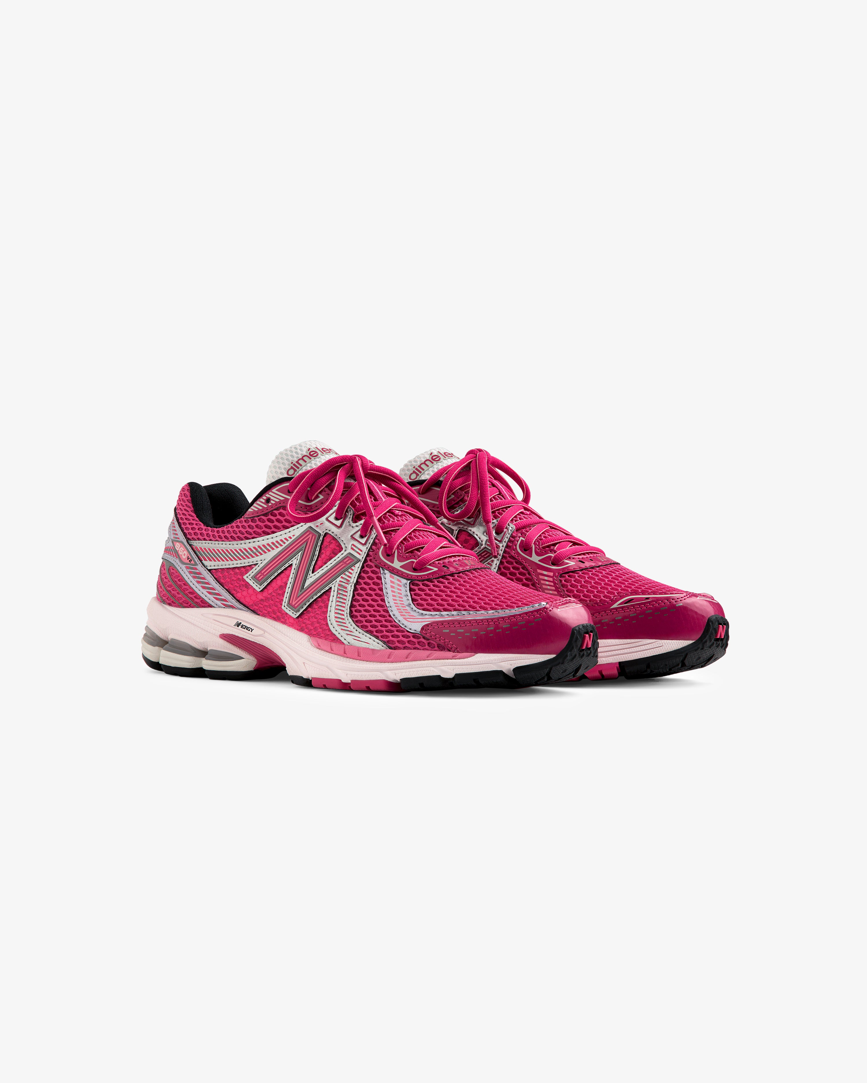 A pair of ALD / New Balance 860v2 pink and gray running shoes with white laces on a white background.