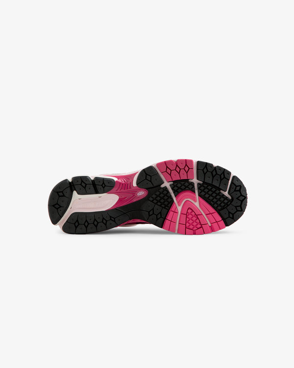 The image shows the black and pink rubber outsole of the ALD / New Balance 860v2 running shoe, viewed from below.