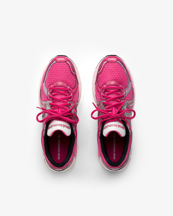 A pair of ALD / New Balance 860v2 pink running shoes with laces, viewed from above on a white background.