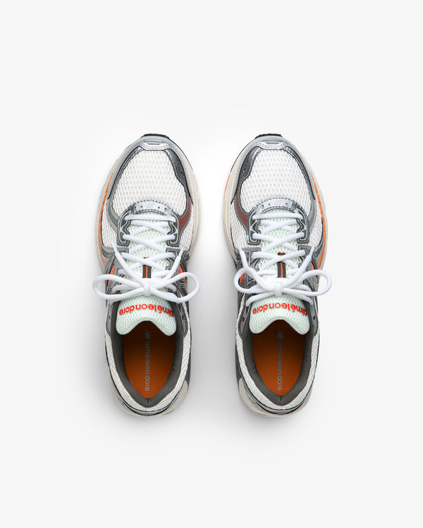 A pair of ALD / New Balance 860v2 sneakers in white, gray, and orange with white laces seen from above.