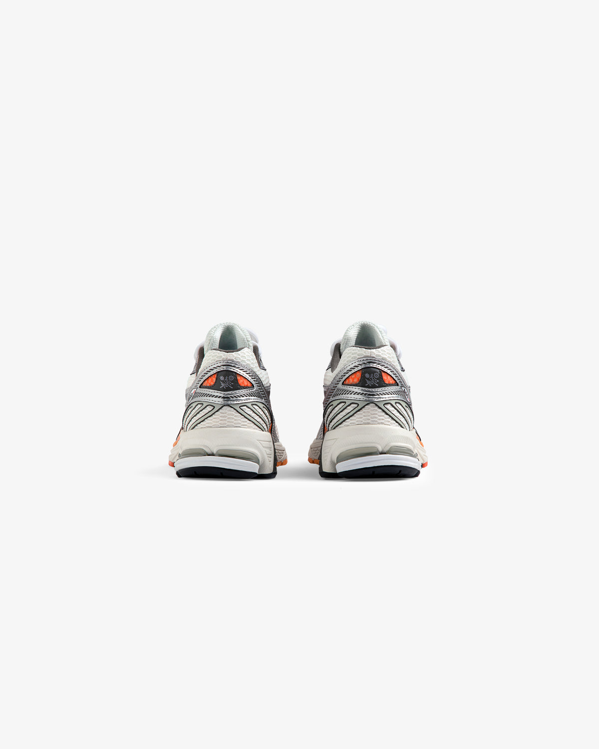 A pair of ALD / New Balance 860v2 sneakers in gray and orange, viewed from the back on a white background.