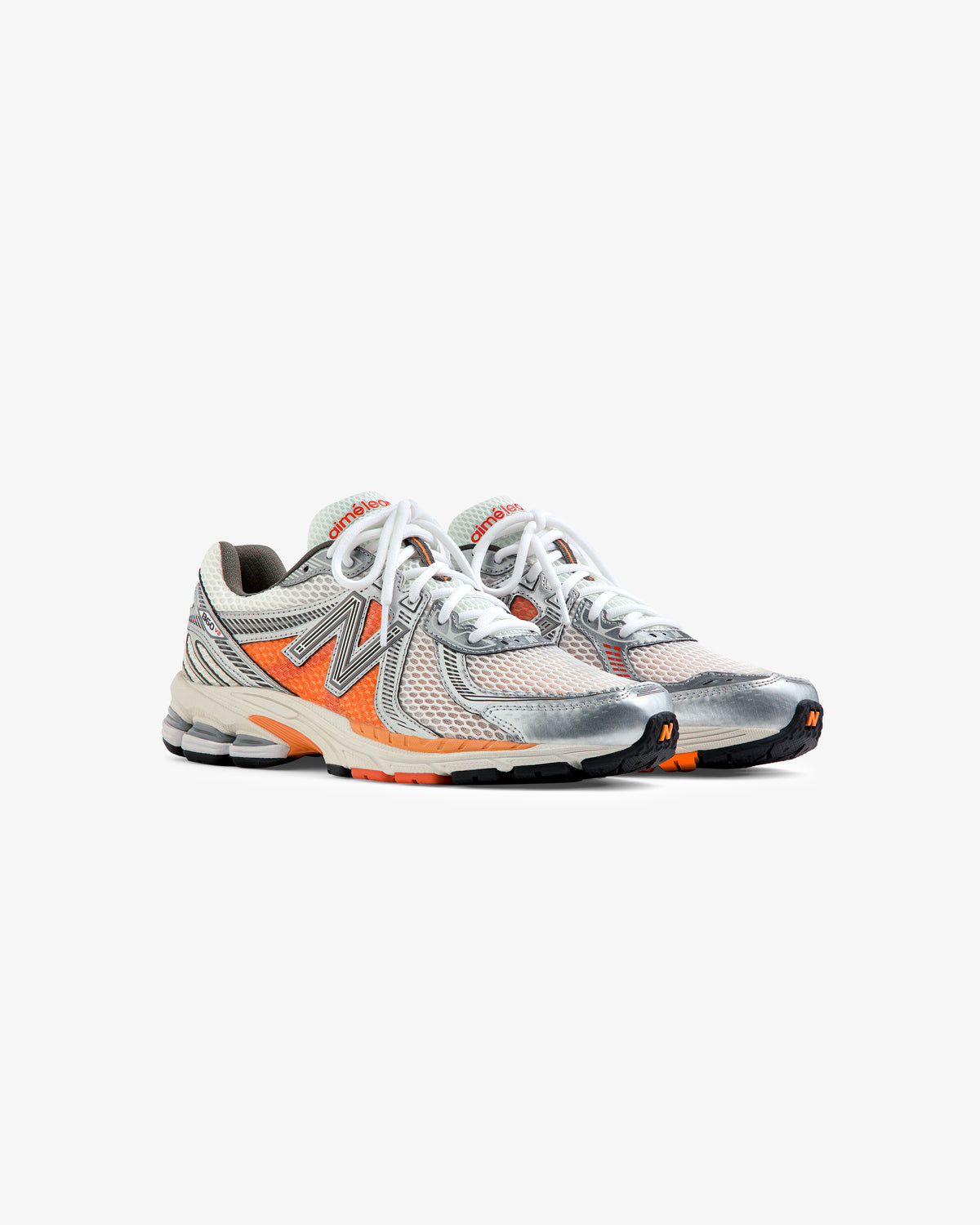 ALD / New Balance 860v2 sneakers in gray, orange, and beige with white laces, shown angled on a white background.