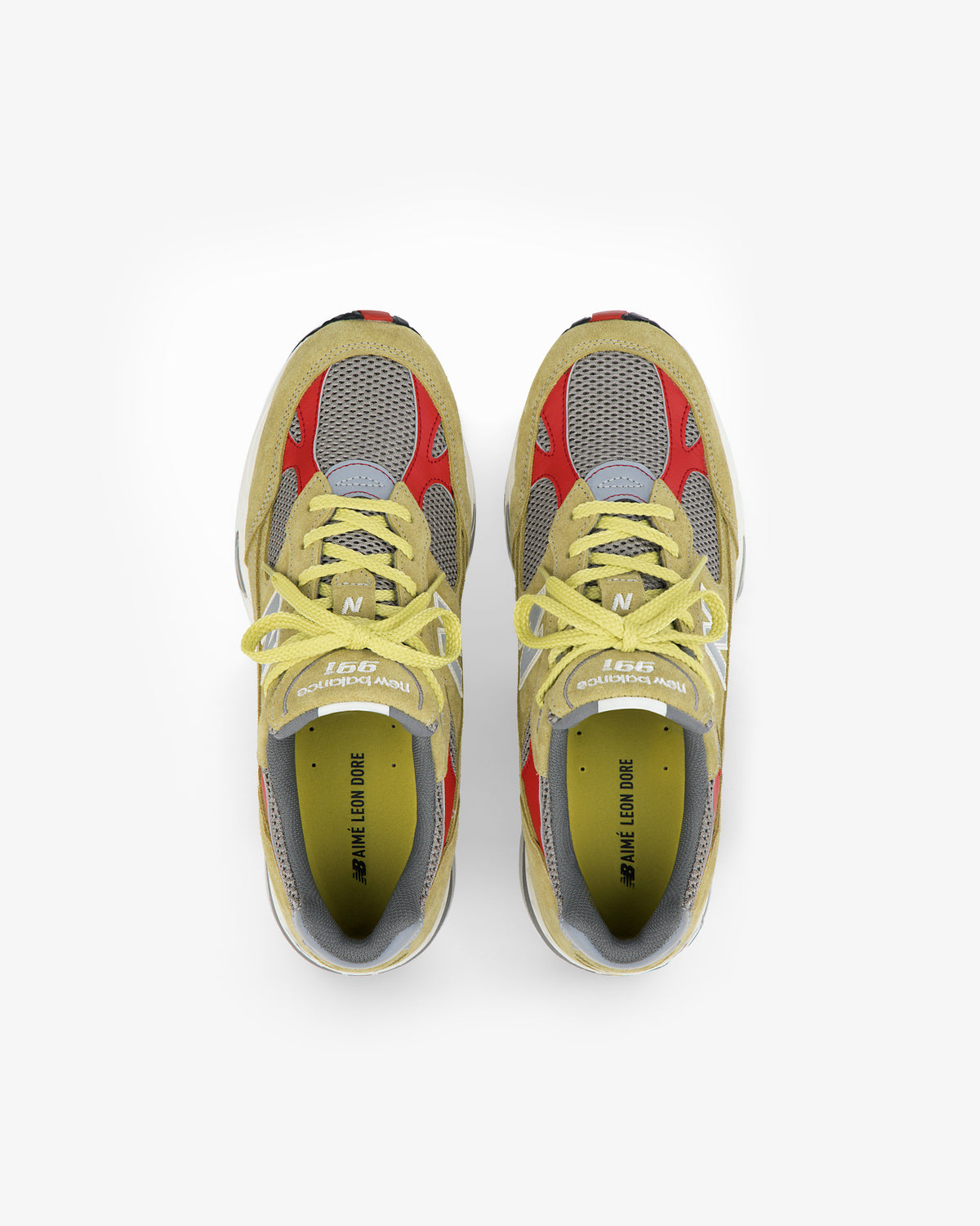 A pair of ALD / New Balance Made in UK 991 sneakers in yellow, red, grey, and beige on a white background.