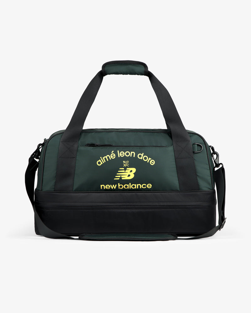 ALD / New Balance Travel Duffle Bag in dark green and black with yellow logos on the front.