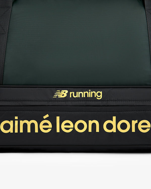 Close-up of the ALD / New Balance Travel Duffle Bag, black with yellow branding.