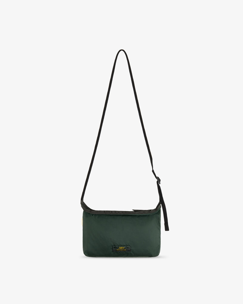 ALD / New Balance Nylon Sling Pouch in dark green with black adjustable strap on a white background.