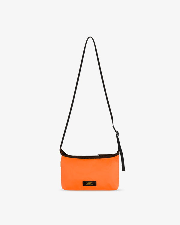 ALD / New Balance Nylon Sling Pouch in bright orange with long black strap and small black front label on white background.