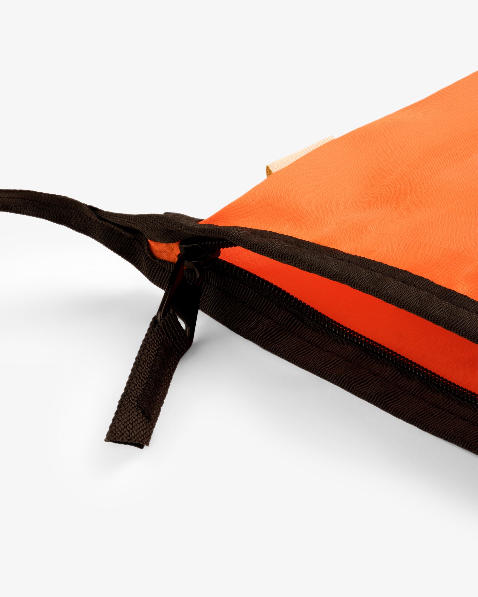 The ALD / New Balance Nylon Sling Pouch in orange with a black zipper, partially open on a white background.