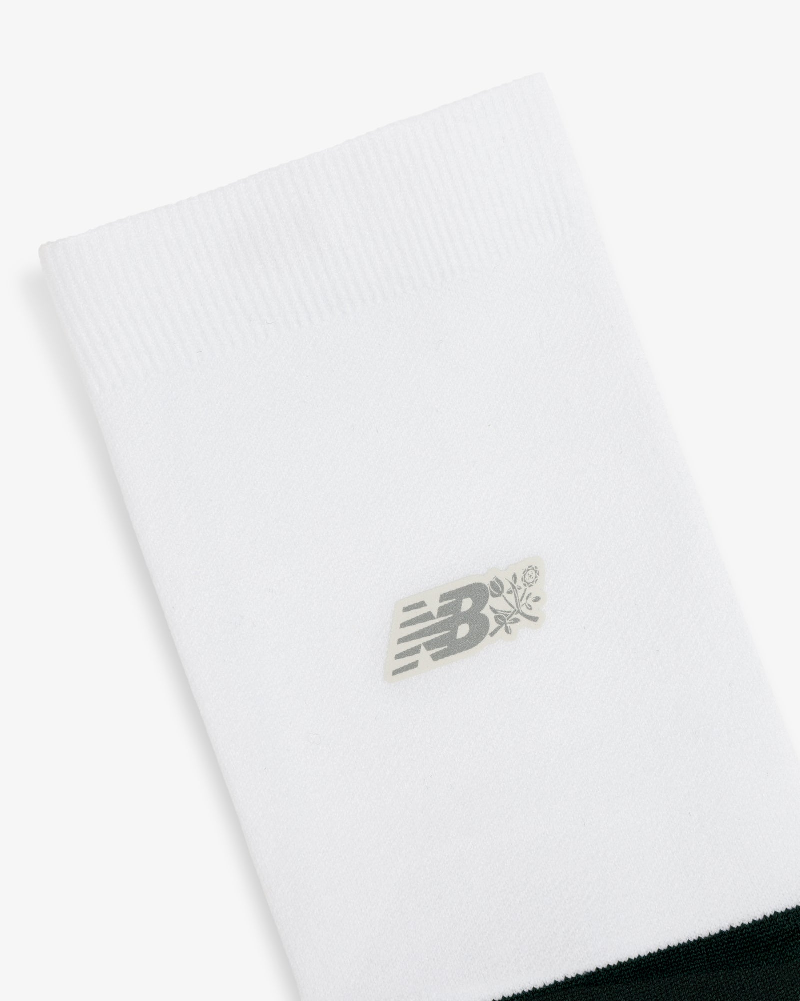 ALD / New Balance Running Crew Sock featuring a gray logo and small flower graphic near the top on white.