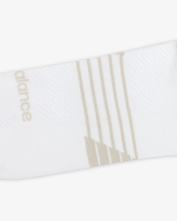 ALD / New Balance Running Crew Sock in white with beige diagonal stripes and side text on a white background.
