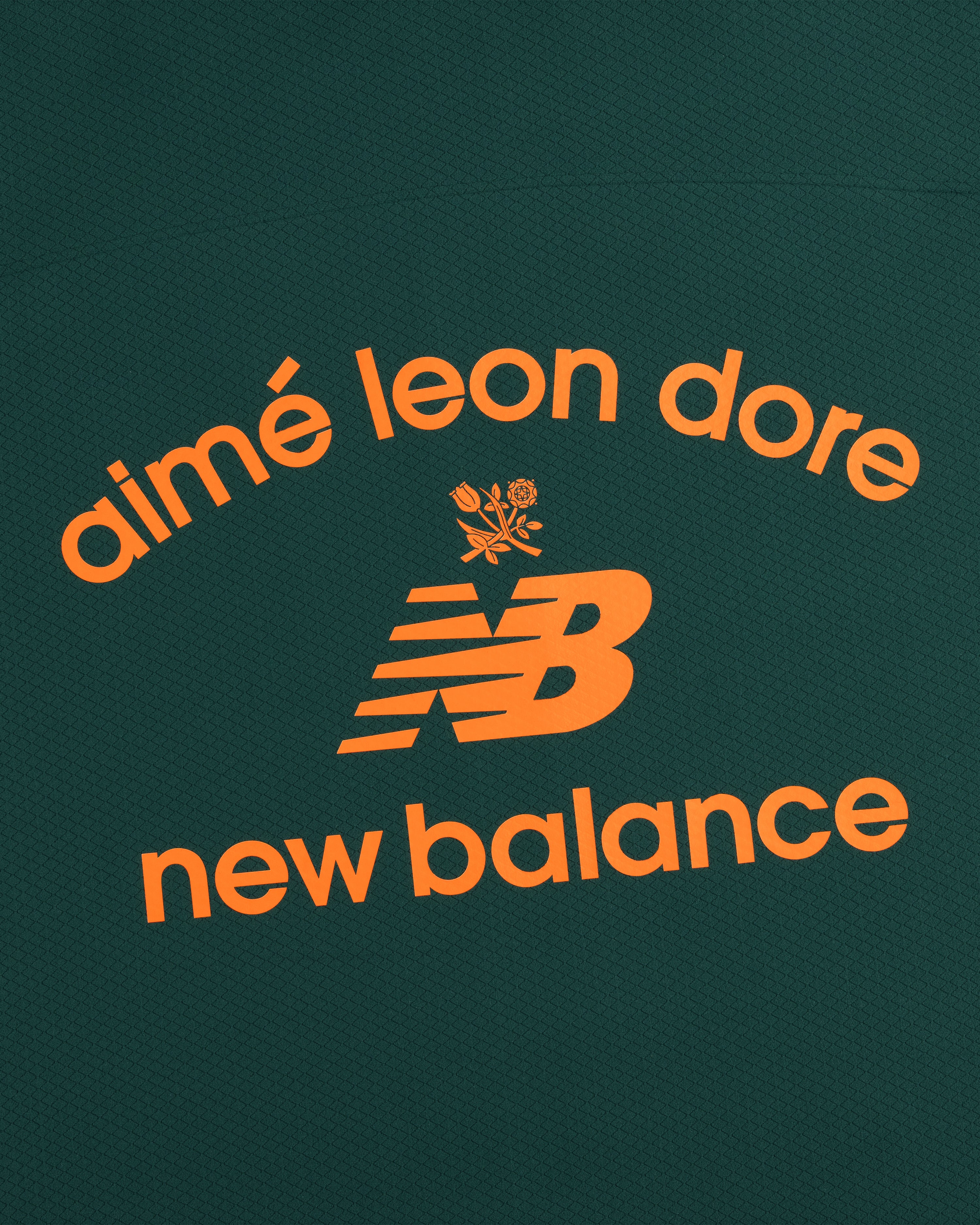 Orange "aimé leon dore" and New Balance text with NB logo and rose on dark green ALD / New Balance Full-Zip Warmup Hoodie.