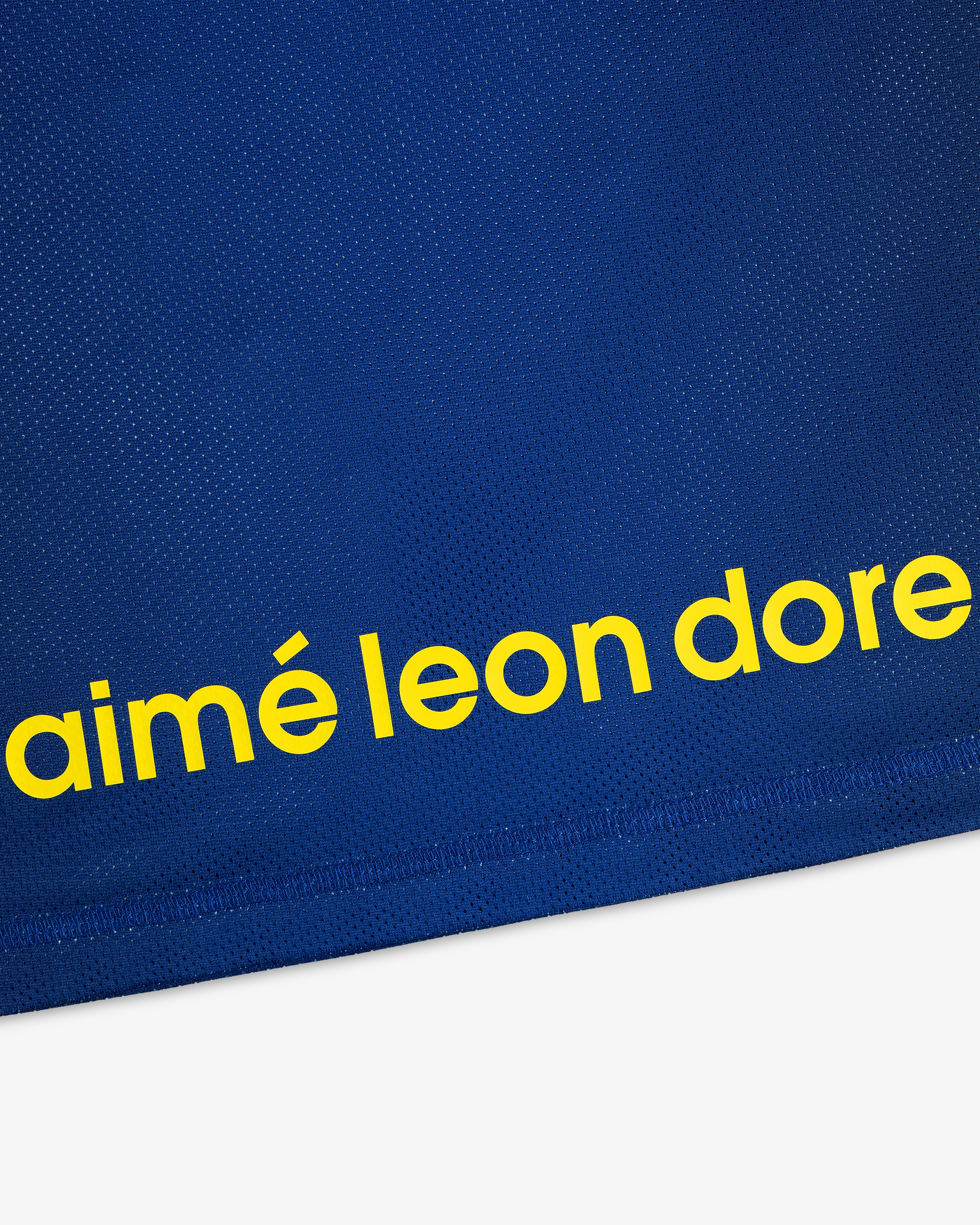 Blue ALD / New Balance Running Gradient Singlet with 'aimé leon dore' in bold yellow lowercase near the bottom.