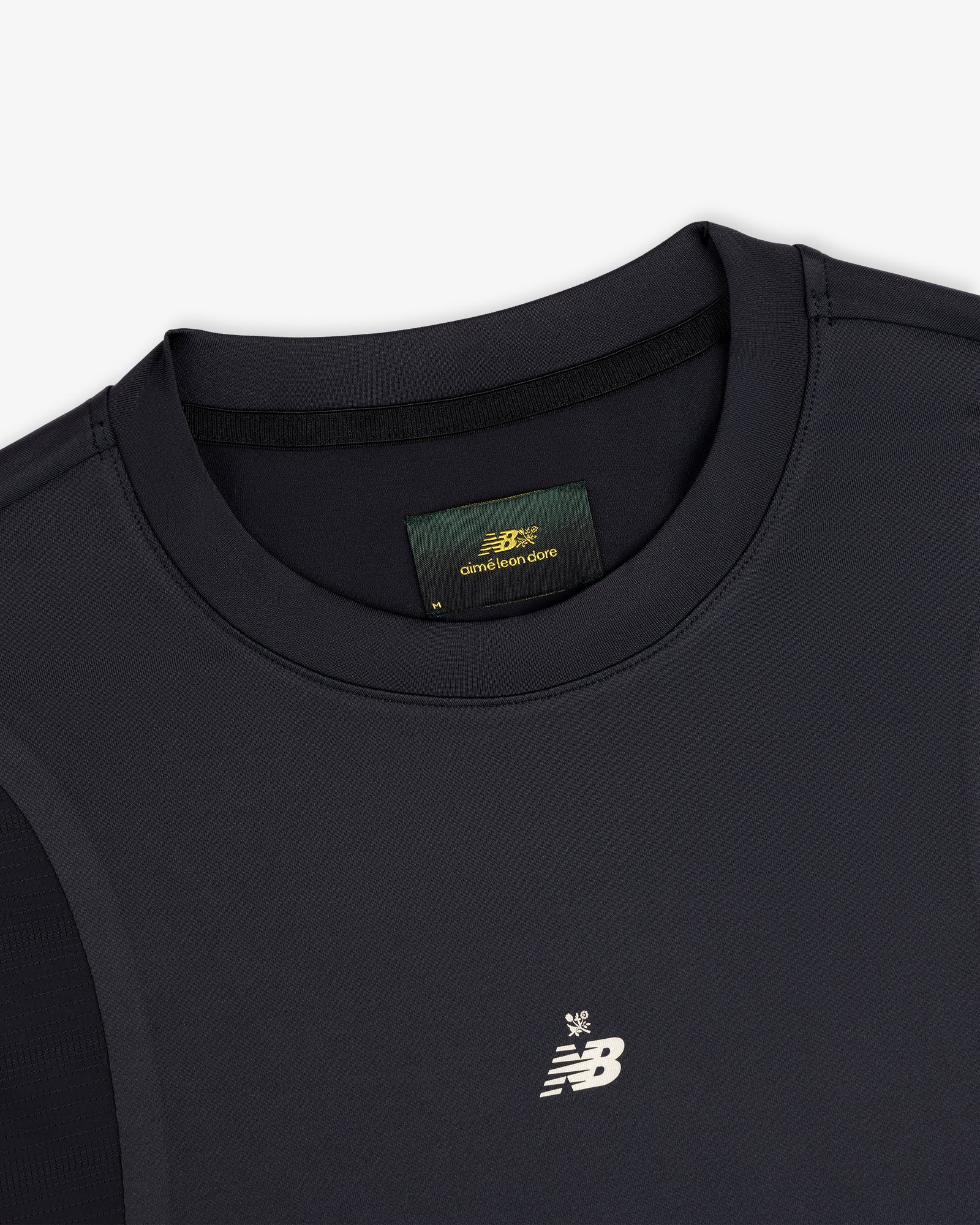Close-up of a black ALD / New Balance Performance Long-Sleeve Tee with small logo and visible green collar label.