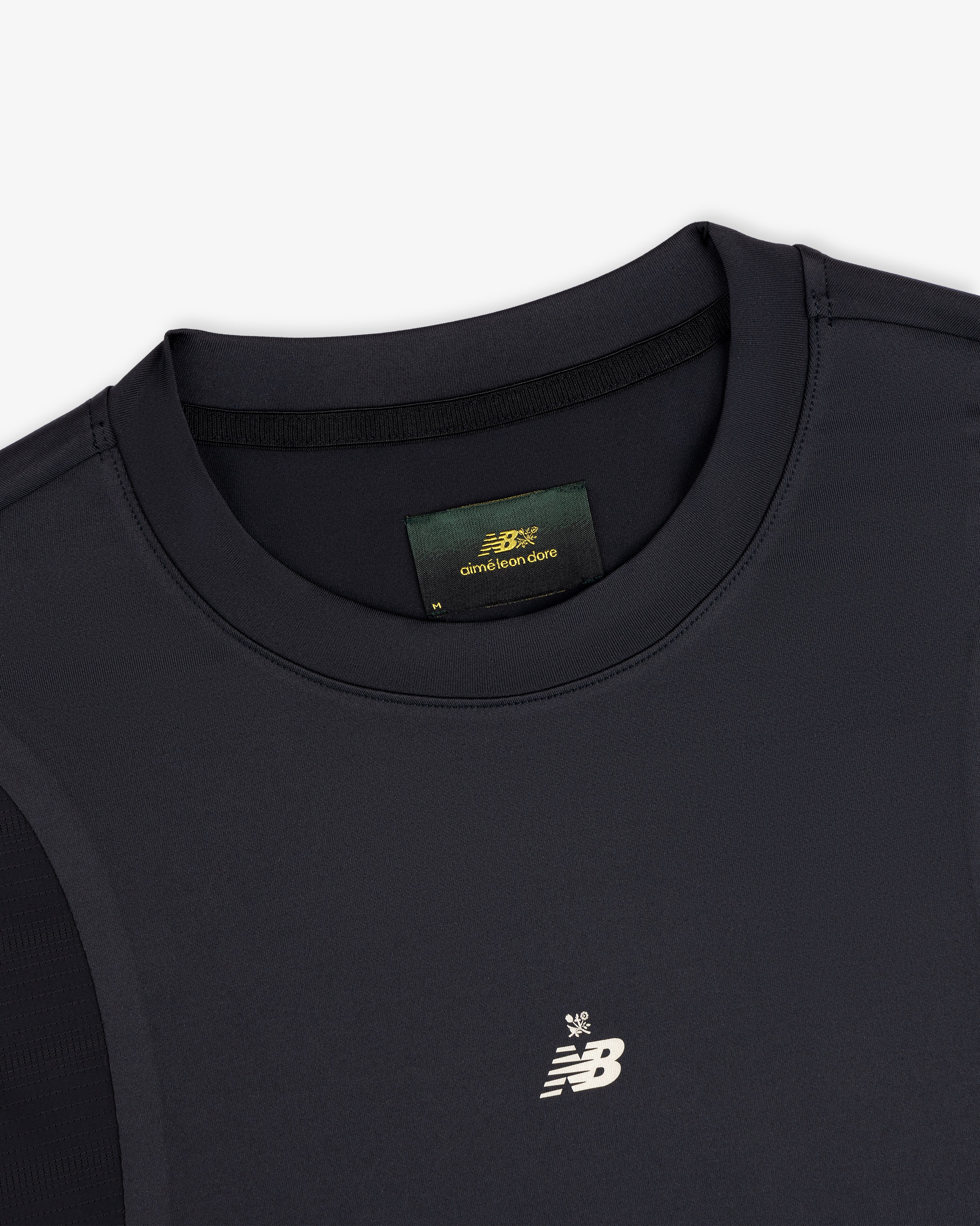 Close-up of a black ALD / New Balance Performance Long-Sleeve Tee with small logo and visible green collar label.