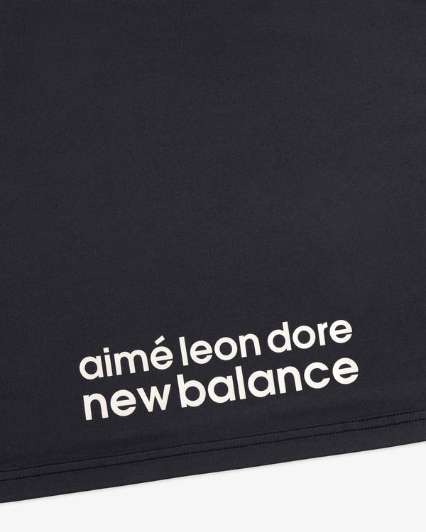Close-up of black fabric from the ALD / New Balance Performance Long-Sleeve Tee with white printed lettering.
