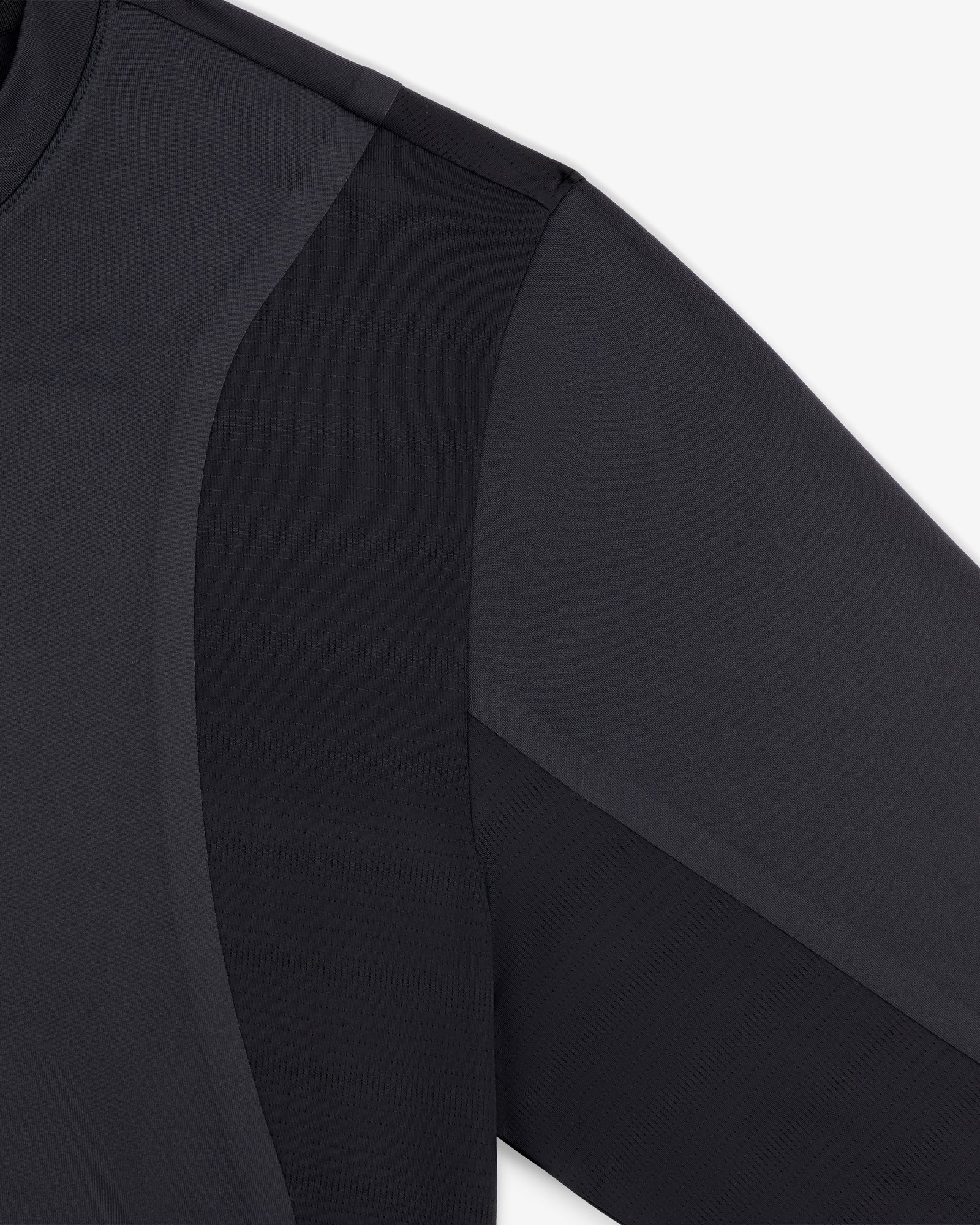 Close-up of the ALD / New Balance Performance Long-Sleeve Tee shows black fabric texture and seam details on shoulder and arm.