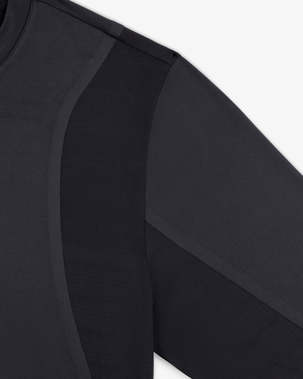 Close-up of the ALD / New Balance Performance Long-Sleeve Tee shows black fabric texture and seam details on shoulder and arm.