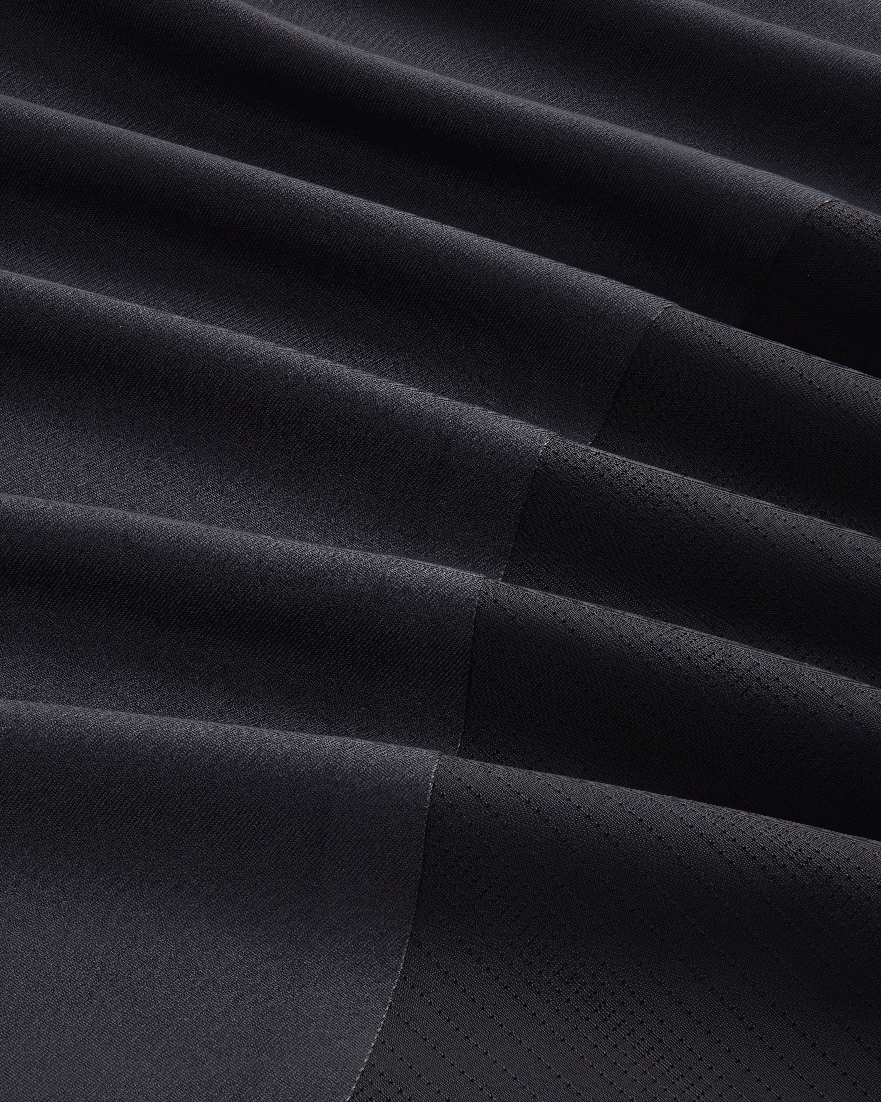 Close-up of ALD / New Balance Performance Long-Sleeve Tee in black with diagonal ribbing and stitched geometric lines.
