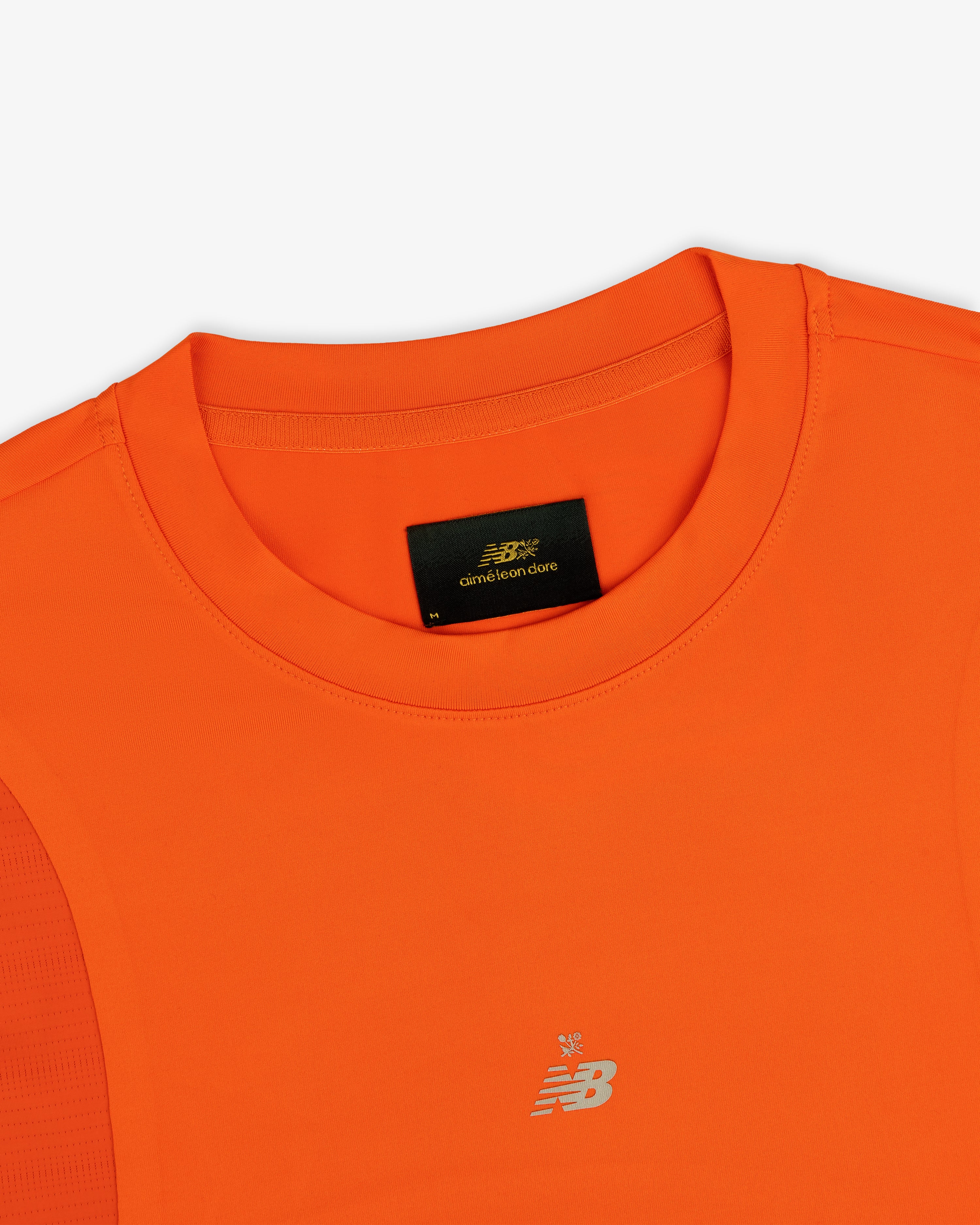 Bright orange ALD/New Balance Performance Long-Sleeve Tee with crew neckline and small silver chest logo.