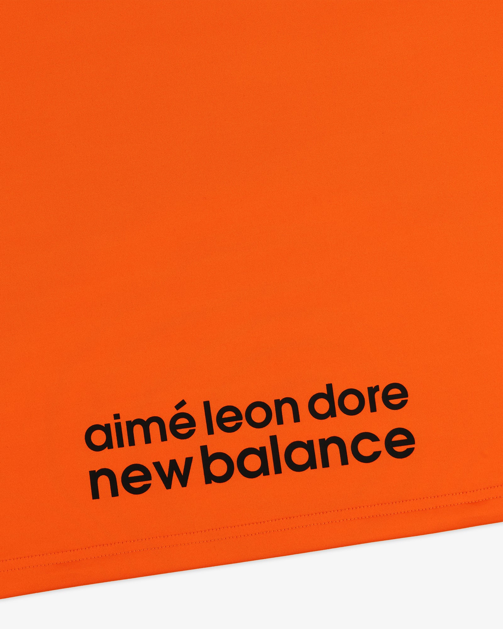 Bright orange ALD / New Balance Performance Long-Sleeve Tee with bold black branding near the bottom edge.