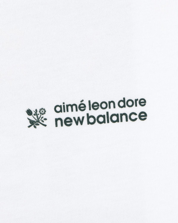 ALD / New Balance Running Bib Tee with black text and floral graphic on white fabric background.