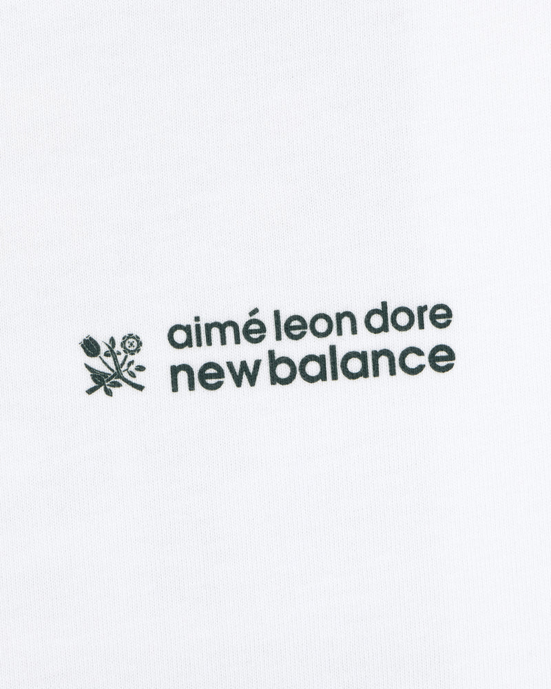 ALD / New Balance Running Bib Tee with black text and floral graphic on white fabric background.
