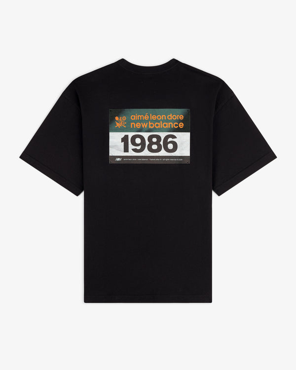 ALD / New Balance Running Bib Tee in black with rectangular "aimé leon dore new balance 1986" graphic on back.