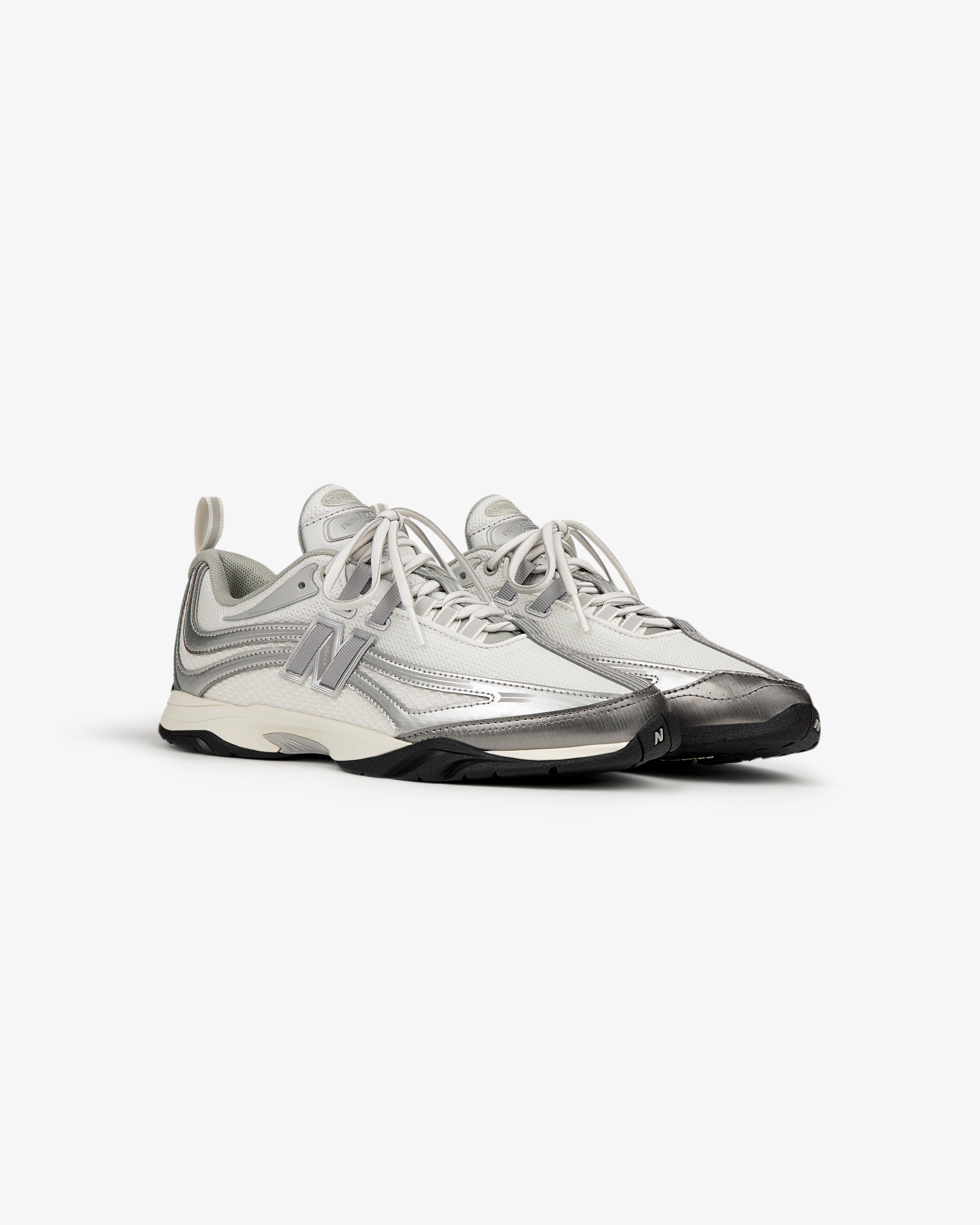 The ALD / New Balance RC56 are gray and white lace-up athletic sneakers with a large N logo on the side.
