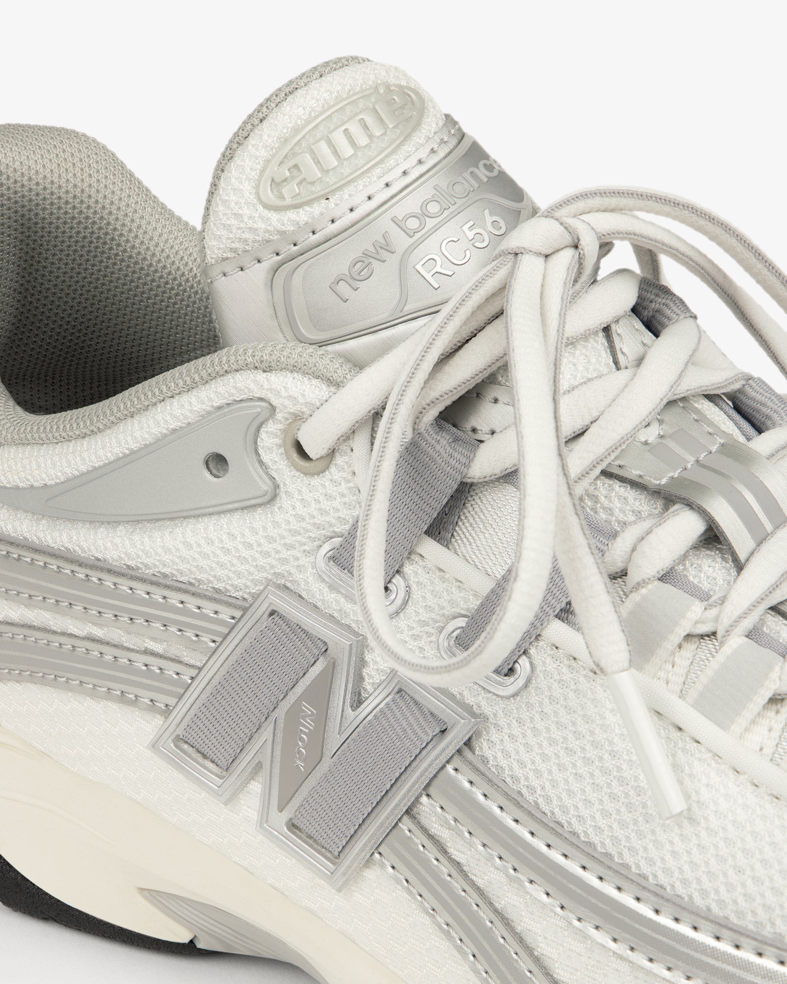 Close-up of a white and gray ALD / New Balance RC56 sneaker with laces and a bold N logo on the side.