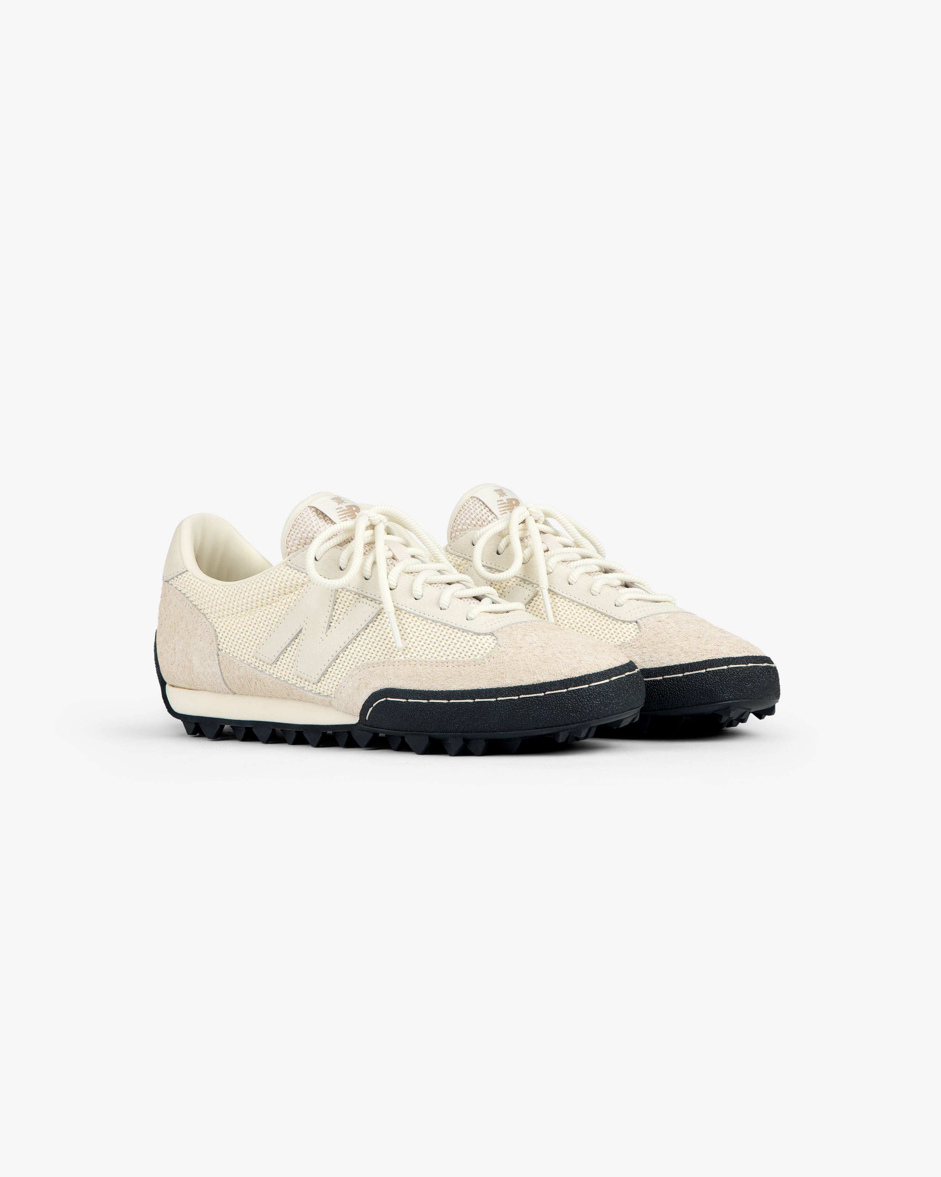 The ALD / New Balance Gator sneakers have off-white textured uppers, cream laces, and black rugged soles.