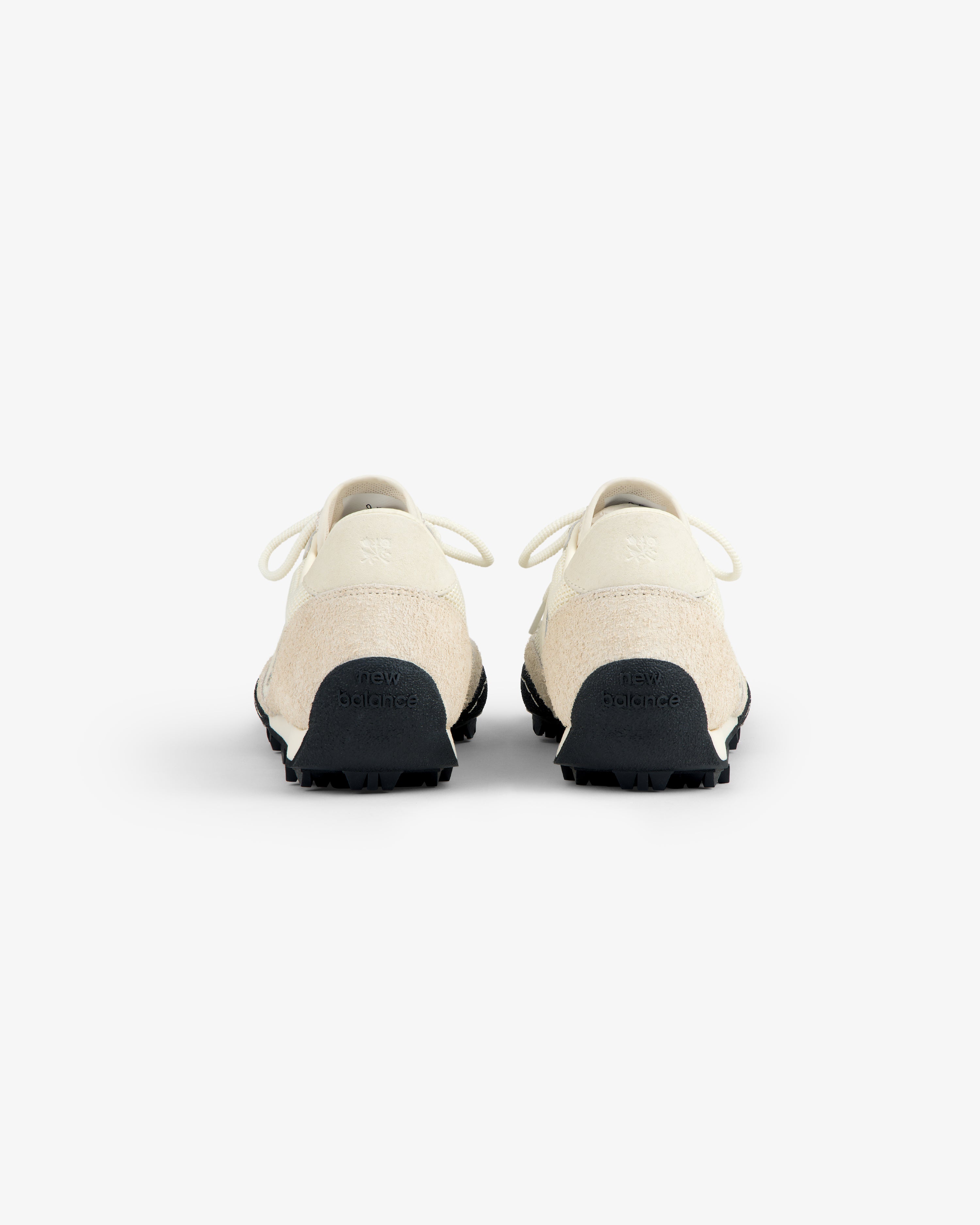 Rear view of ALD / New Balance Gator sneakers in off-white with black soles on a plain white background.
