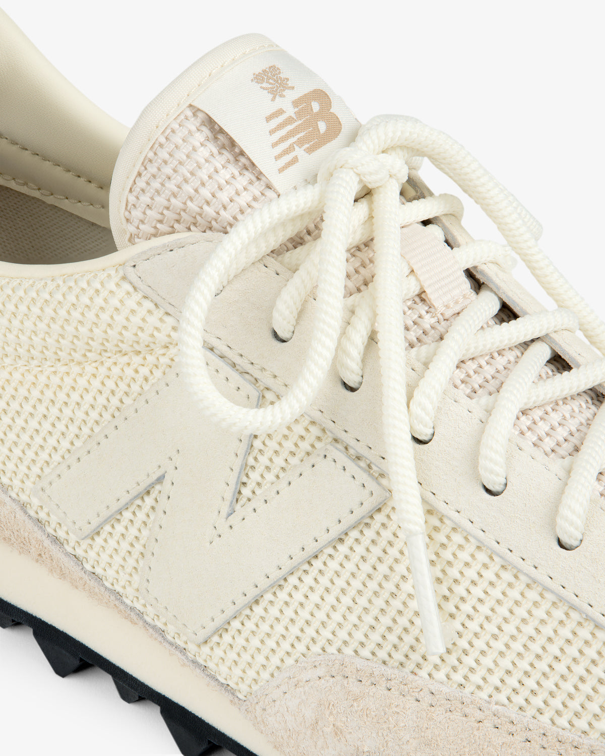 Close-up of a cream ALD / New Balance Gator sneaker with mesh, suede, laces, and the side N logo.