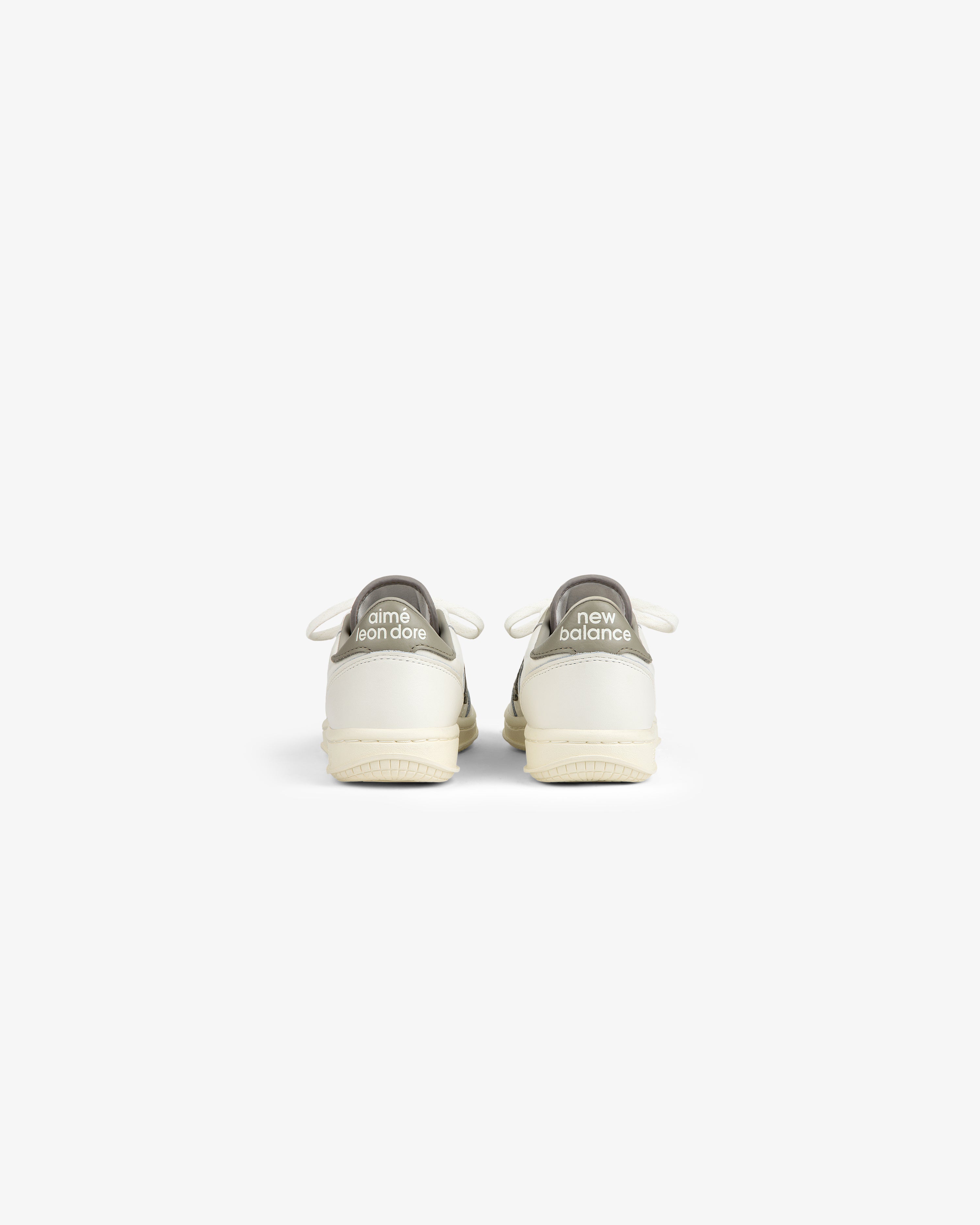 Rear view of ALD / New Balance T500 Tennis Oxfords in off-white with gray branded heel tabs.