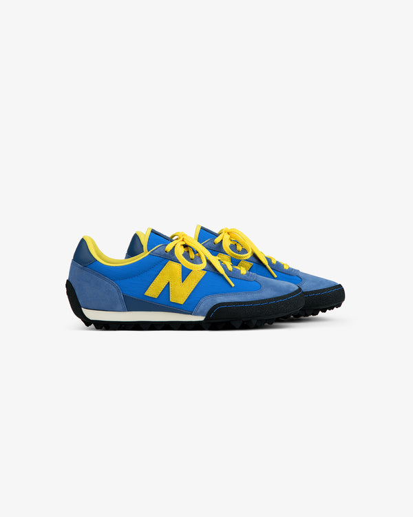 ALD / New Balance Gator sneaker in blue and yellow with a lugged rubber sole and yellow laces.